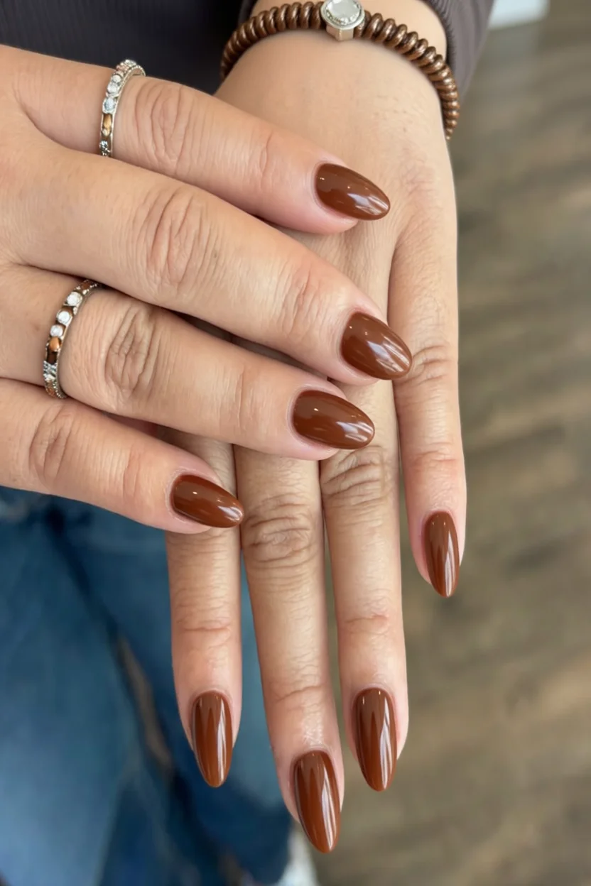 Uñas largas forma almendra en tono marrón caramelo chai con brillo glossy