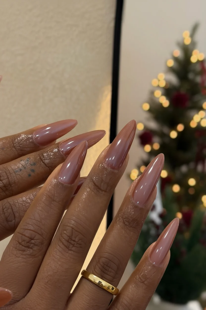 Uñas largas en forma de stiletto con esmalte color chai rosado brillante