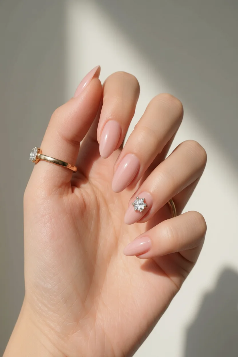 Uñas almendradas con esmalte jelly rosa translúcido y decoración de cristal