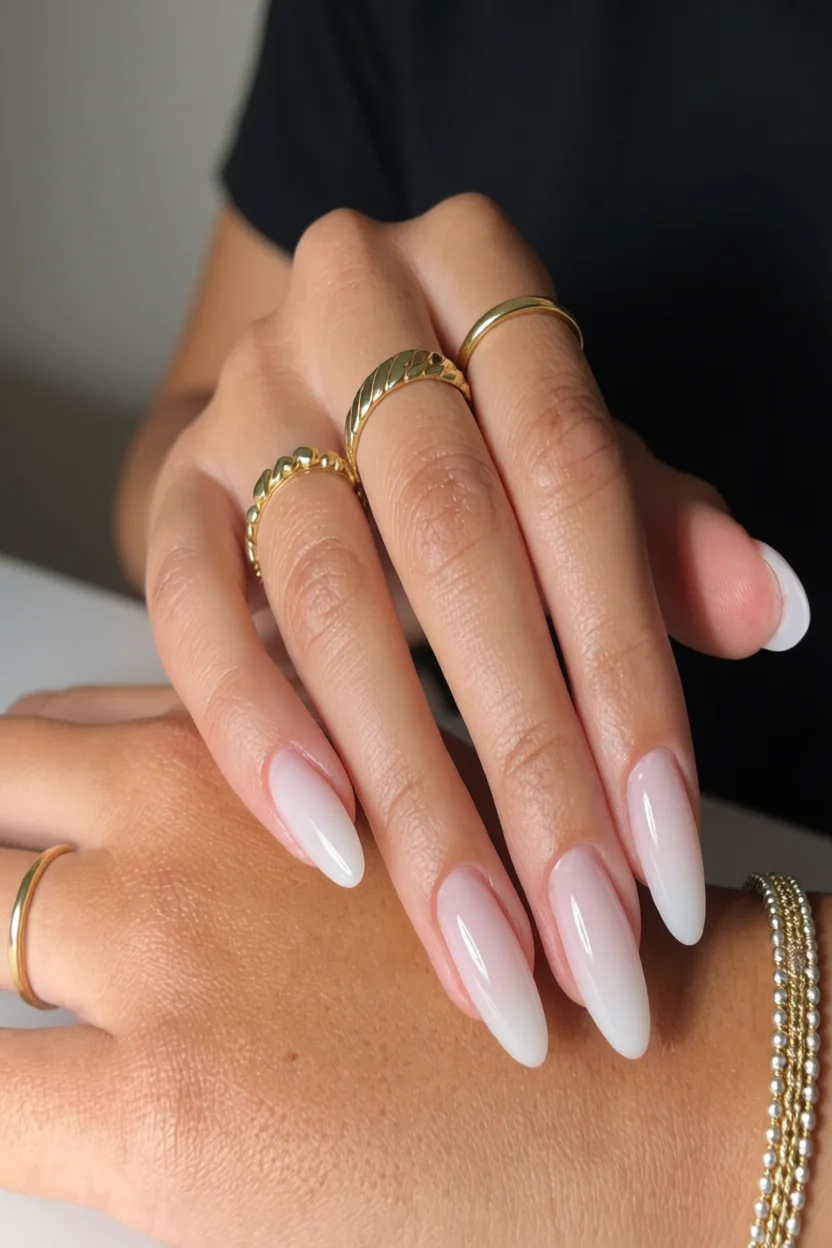 Uñas largas en forma de almendra con efecto milky degradado de rosa a blanco opaco