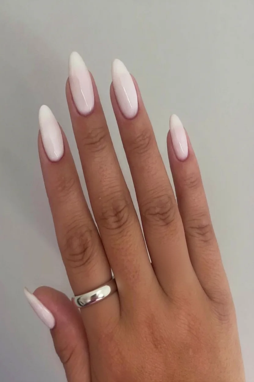 Uñas largas en forma almendra con estilo milky translúcido color blanco porcelánico