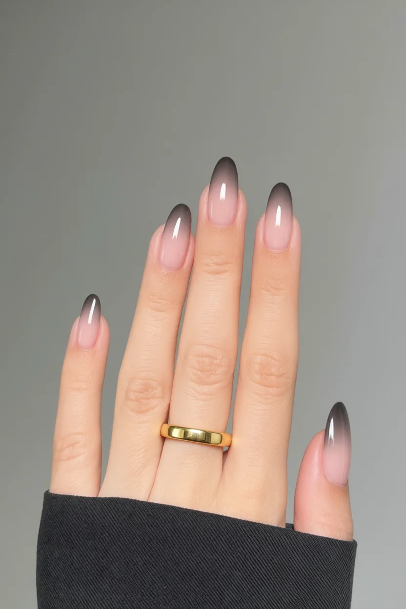 Mano con uñas largas óvalas degradadas de nude a negro
