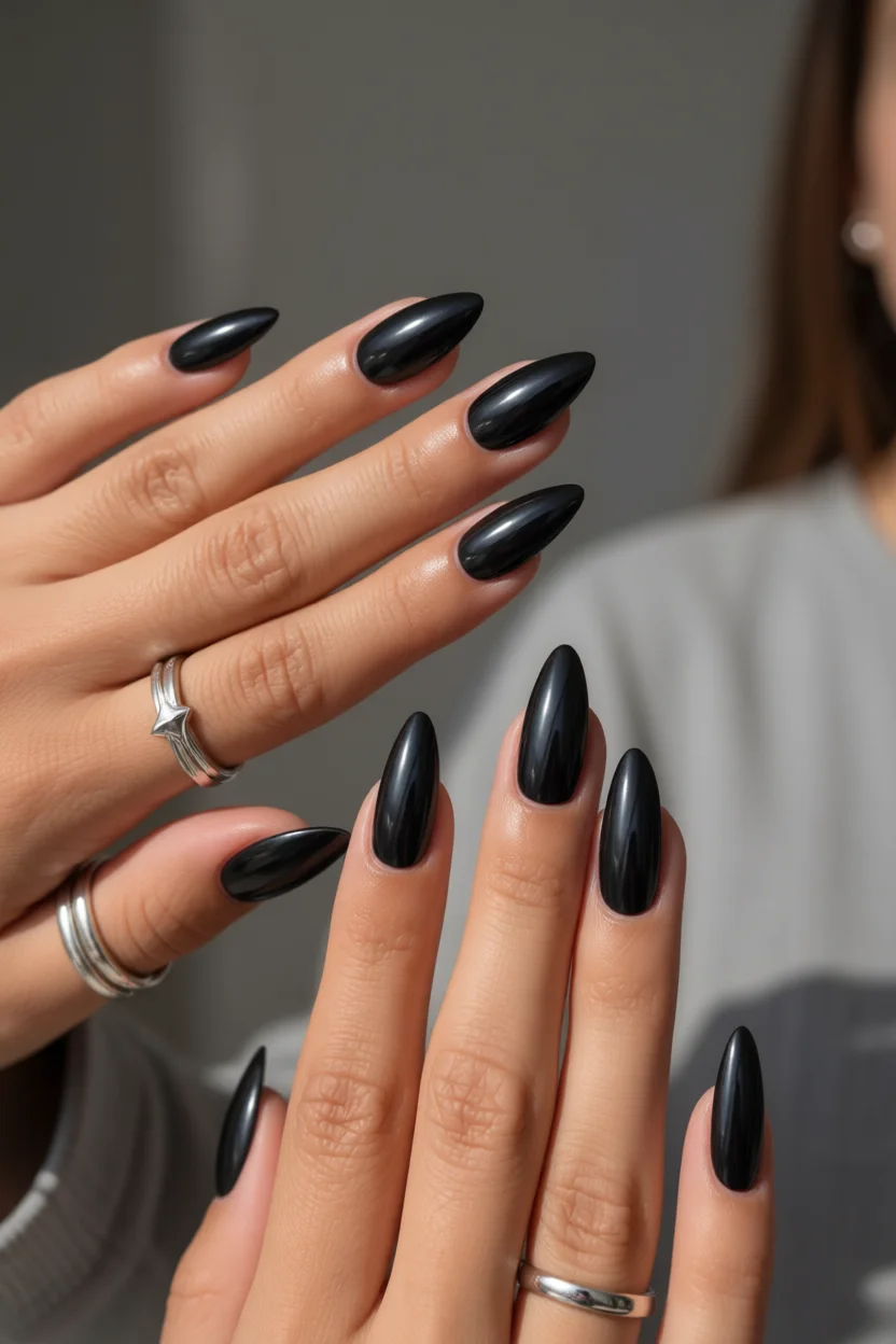 Uñas negras largas con forma almendra y acabado chrome brillante