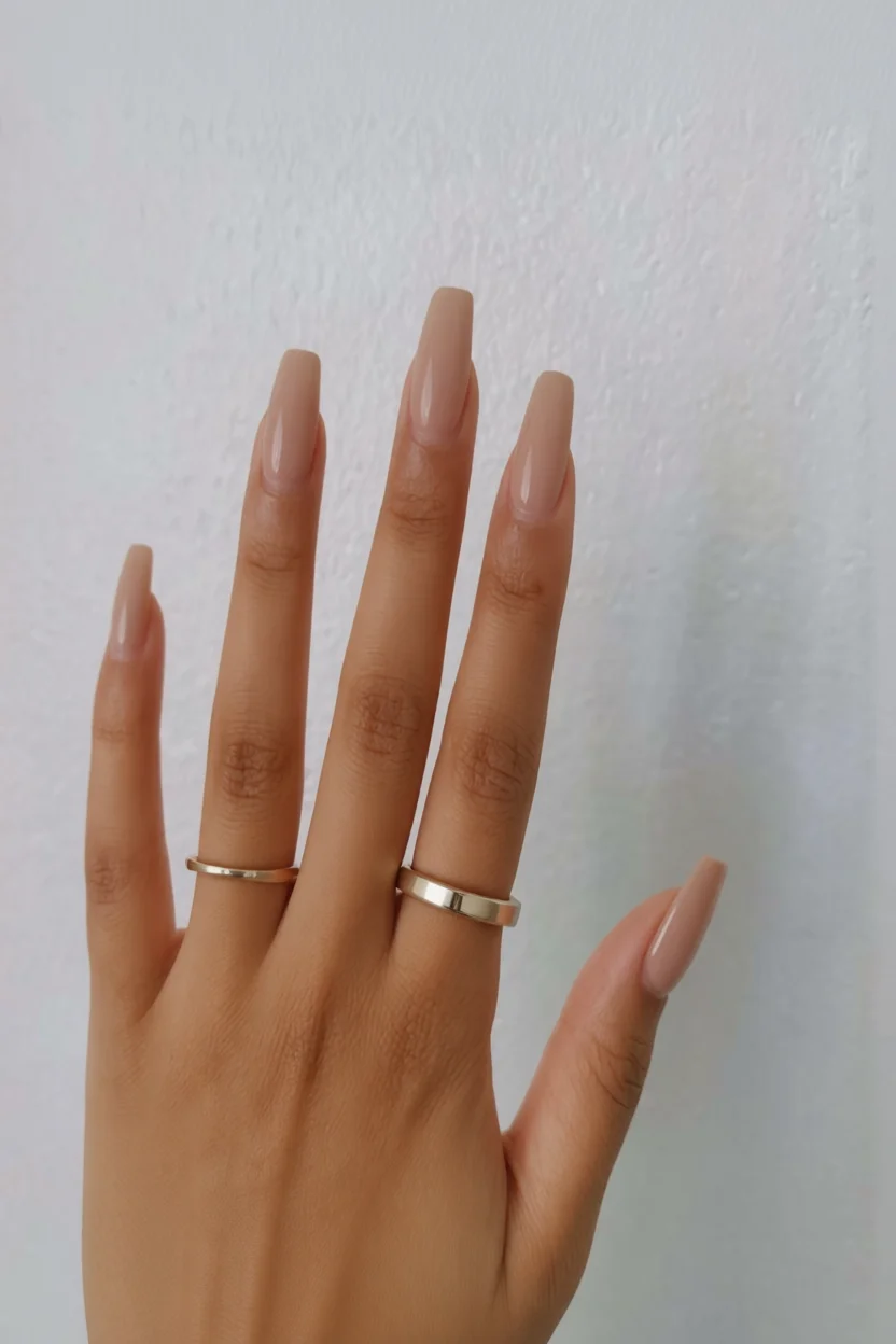 Mano con uñas largas cuadradas pintadas en color chocolate nude brillante
