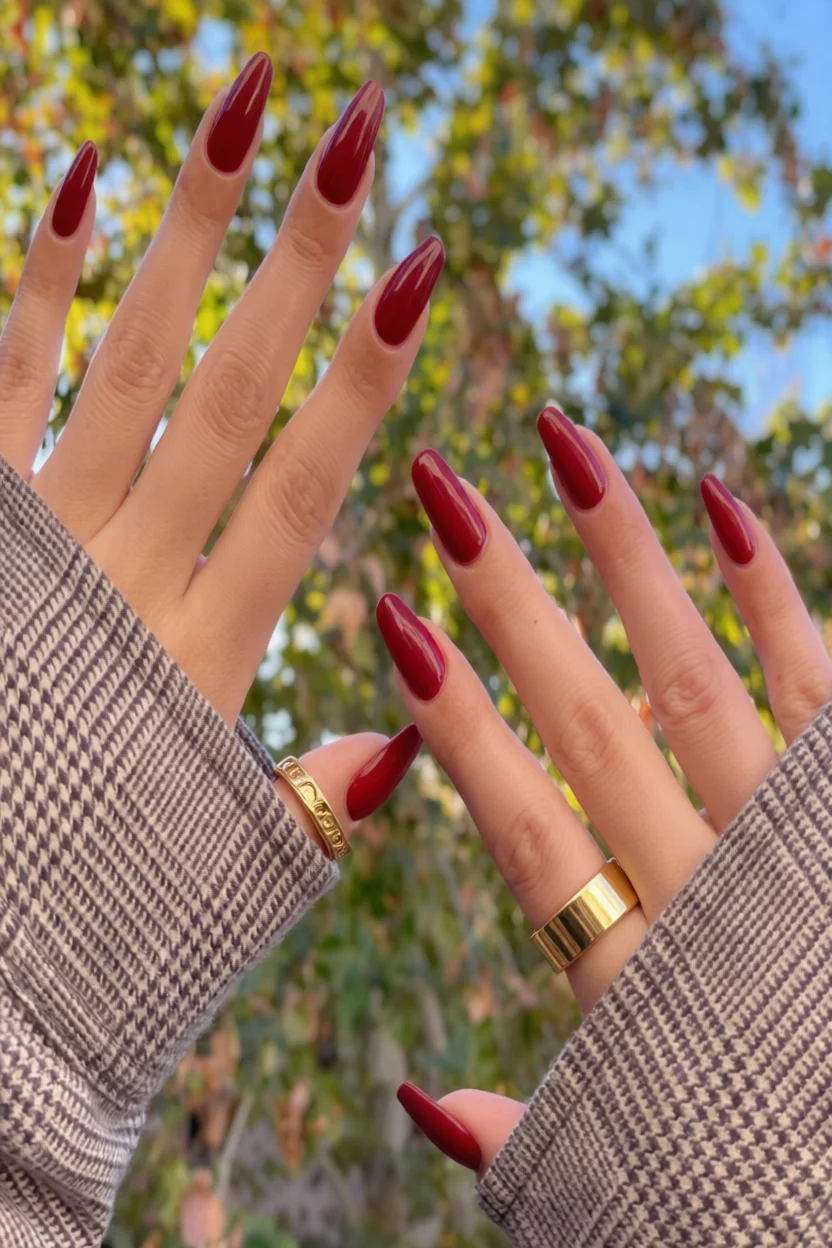 Uñas largas forma almendra con esmalte rojo burdeos brillante