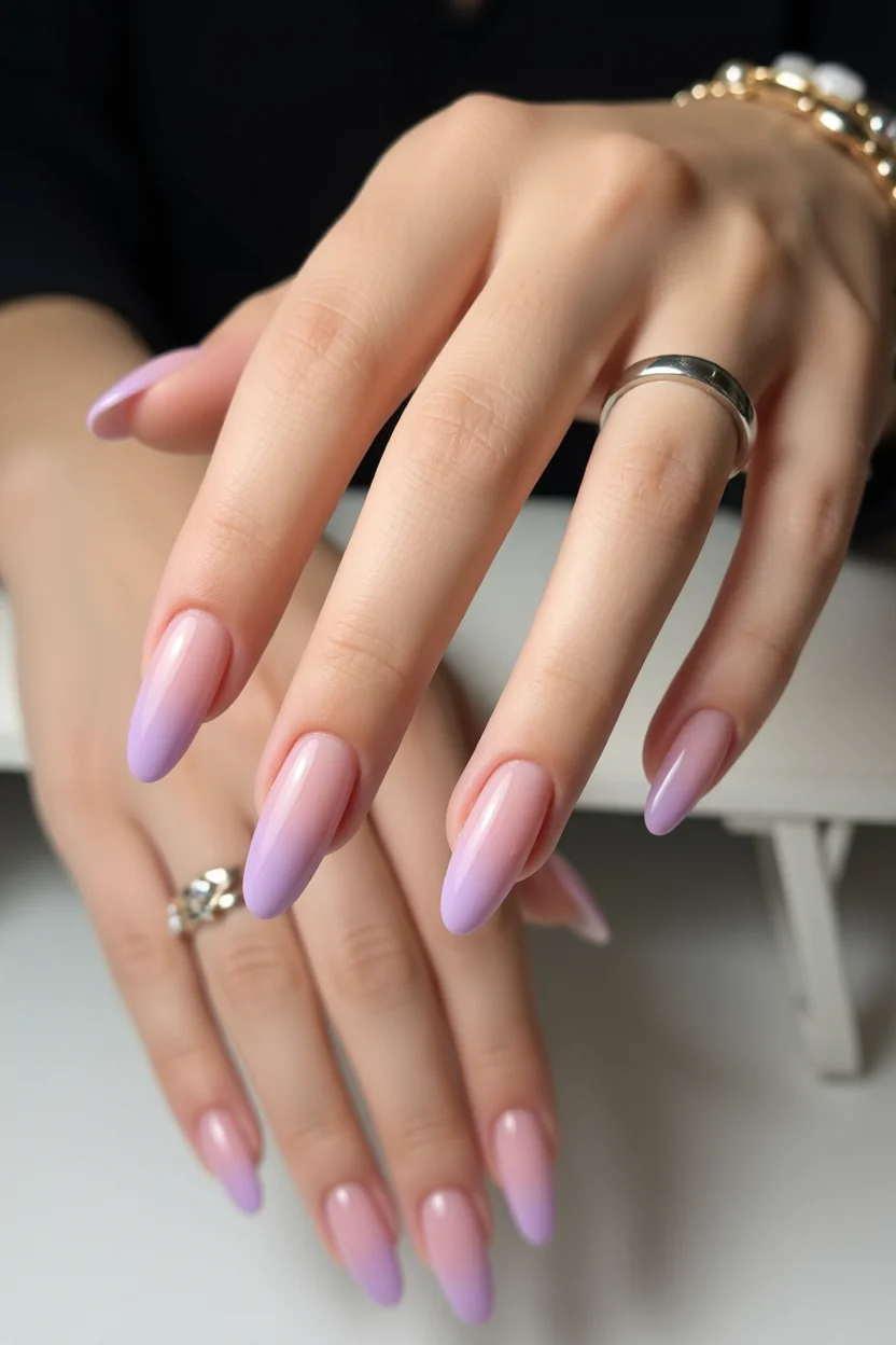 Uñas largas almendradas con degradado ombré de rosa suave a lila en las puntas y brillo glossy