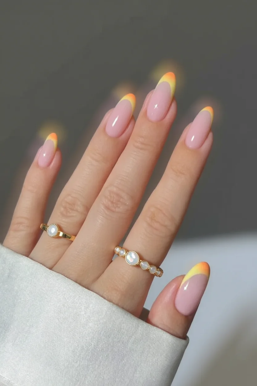 Uñas almendradas con base rosa y puntas en degradado amarillo-naranja estilo francés