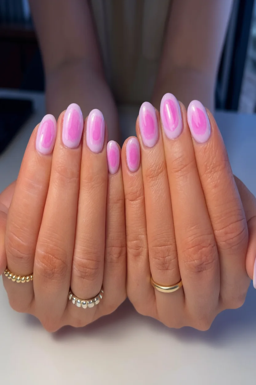 Uñas ovaladas con efecto aura rosa intenso sobre base blanca lechosa