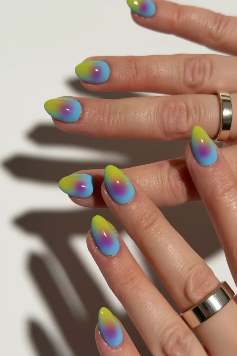 Uñas almendradas con diseño aura en degradado de verde lima, azul y lila