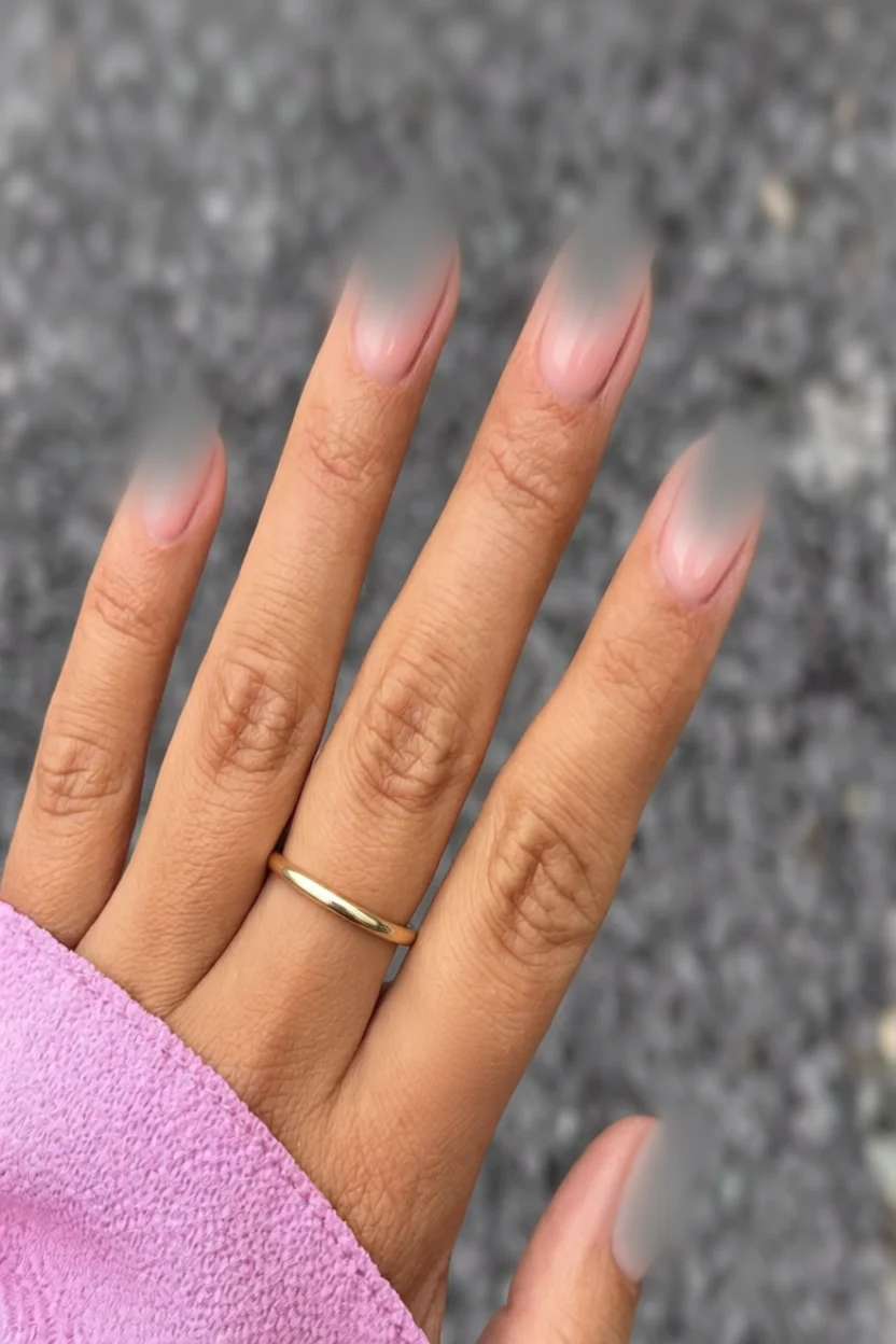 Mano con uñas largas en forma almendrada, diseño francés rosado con efecto degradado suave