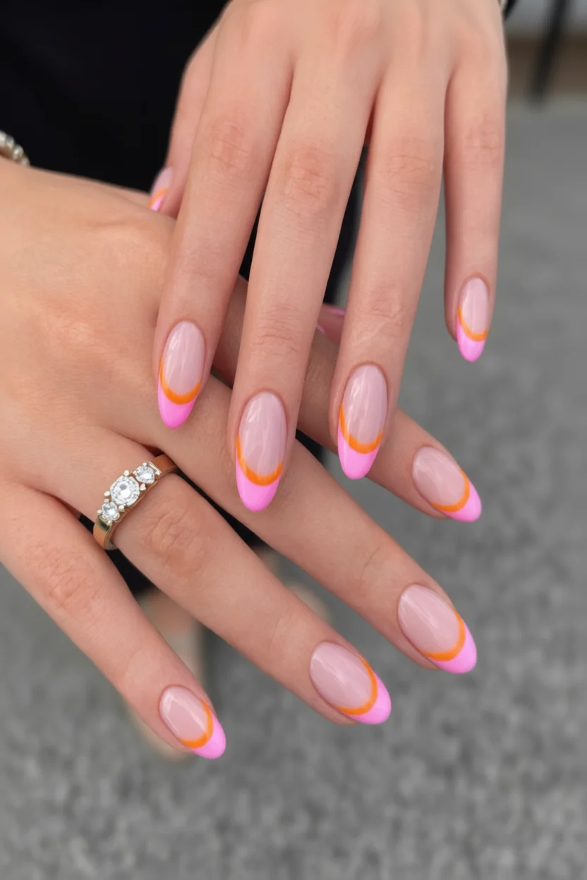 Uñas ovaladas con base rosa y puntas francesas rosas con línea naranja