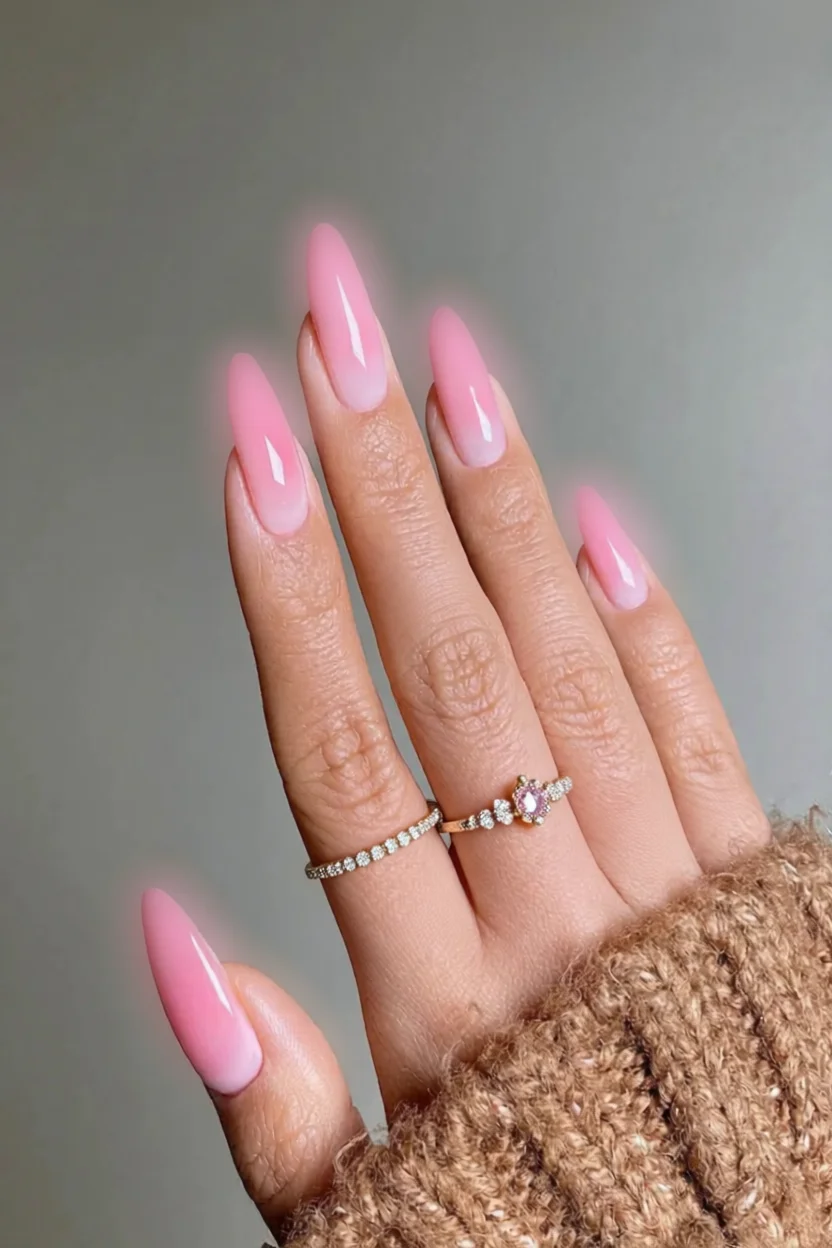 Uñas largas estilo stiletto con efecto ombré en tonos rosa pastel desvaneciéndose hacia blanco en las puntas