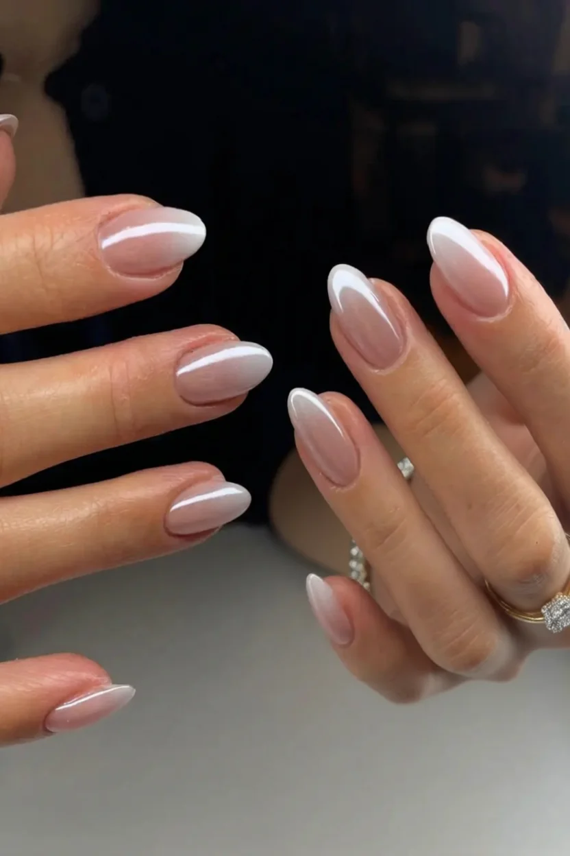 Mano con uñas ovaladas en degradado rosa a blanco brillante