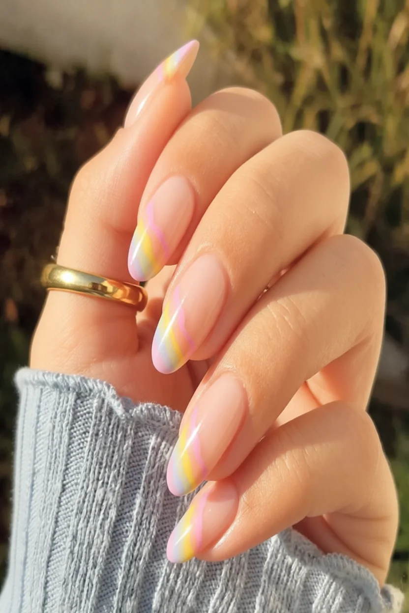 Uñas largas almendradas con diseño de arcoíris sutil en tonos pastel sobre base nude