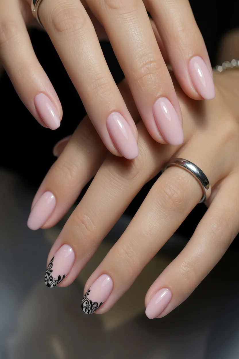 Uñas ovaladas color rosa palo con diseños florales negros en dos dedos
