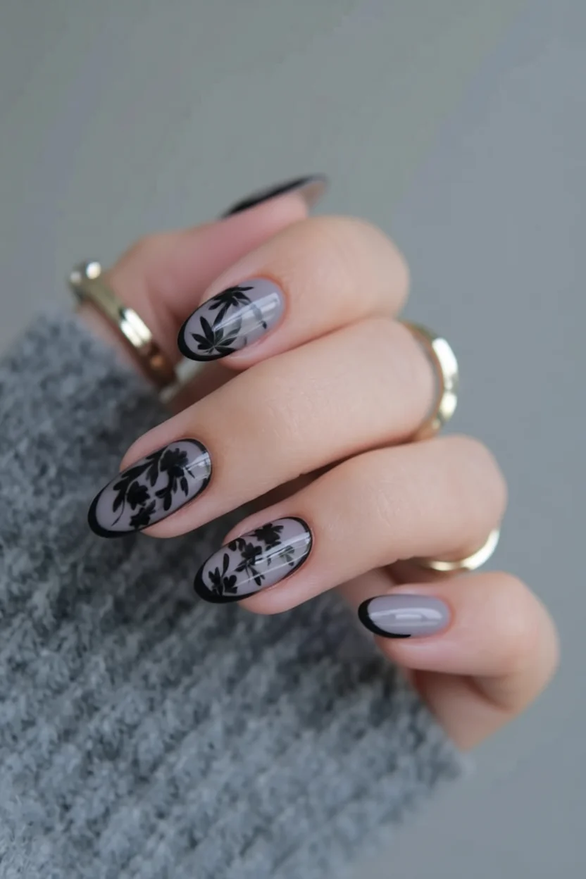 Uñas ovaladas con base gris translúcida y flores negras