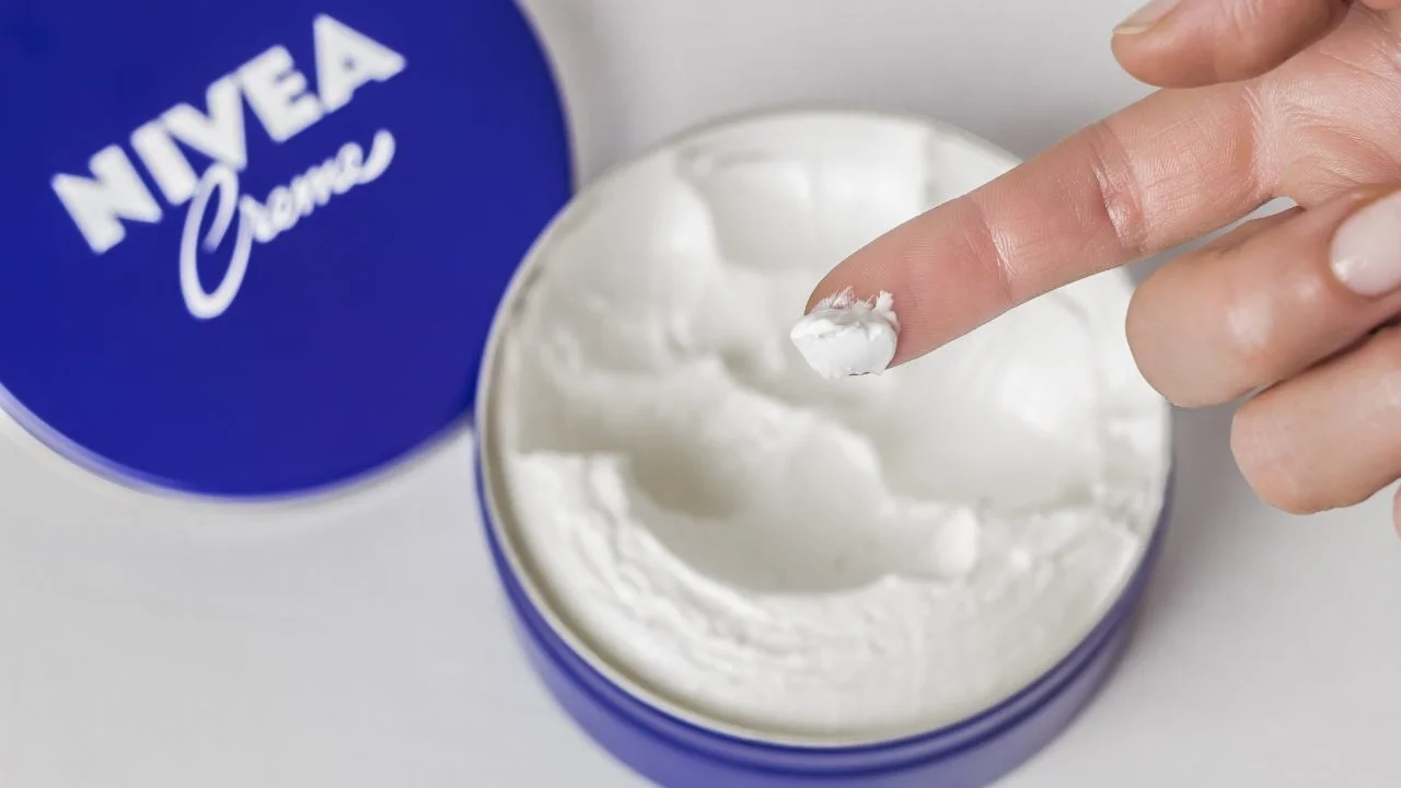 Manos aplicándose una mezcla de crema hidratante con aceite de oliva