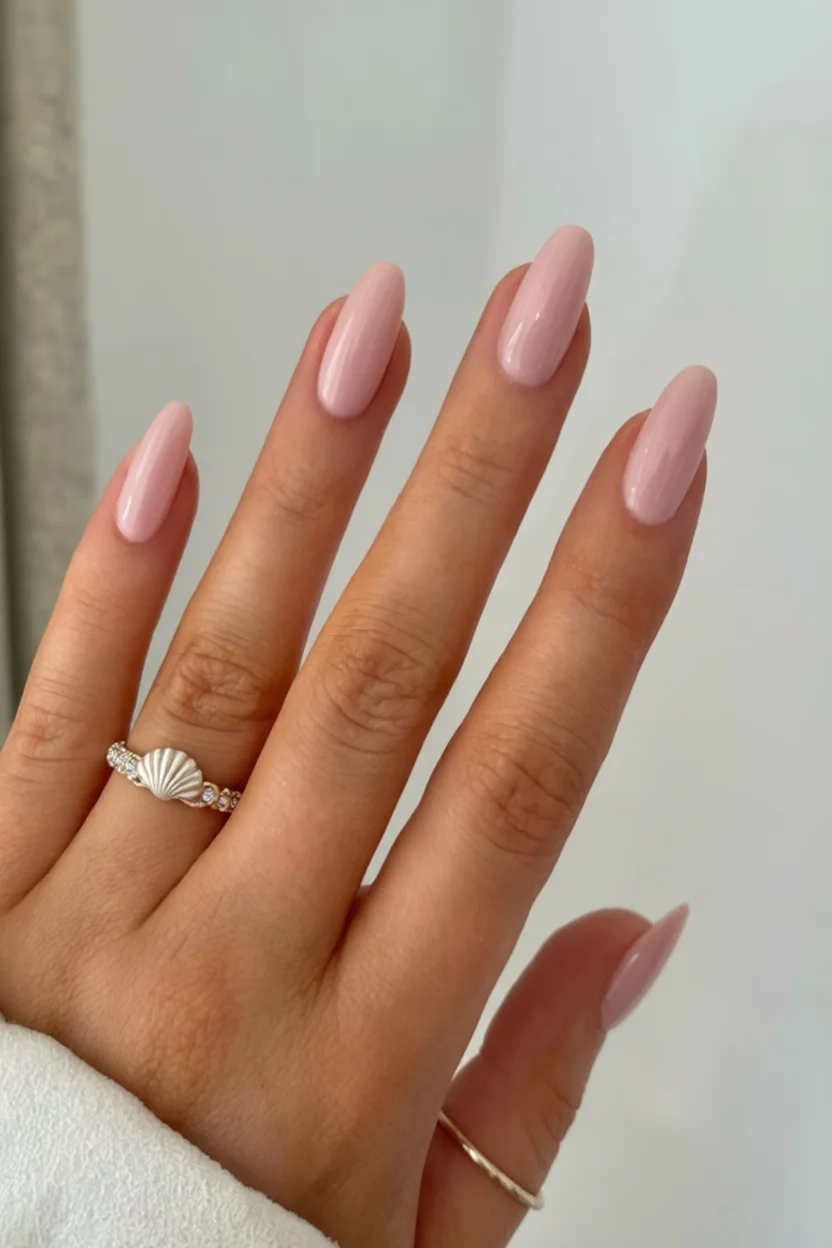 Uñas largas color rosa pastel con anillo de concha marina