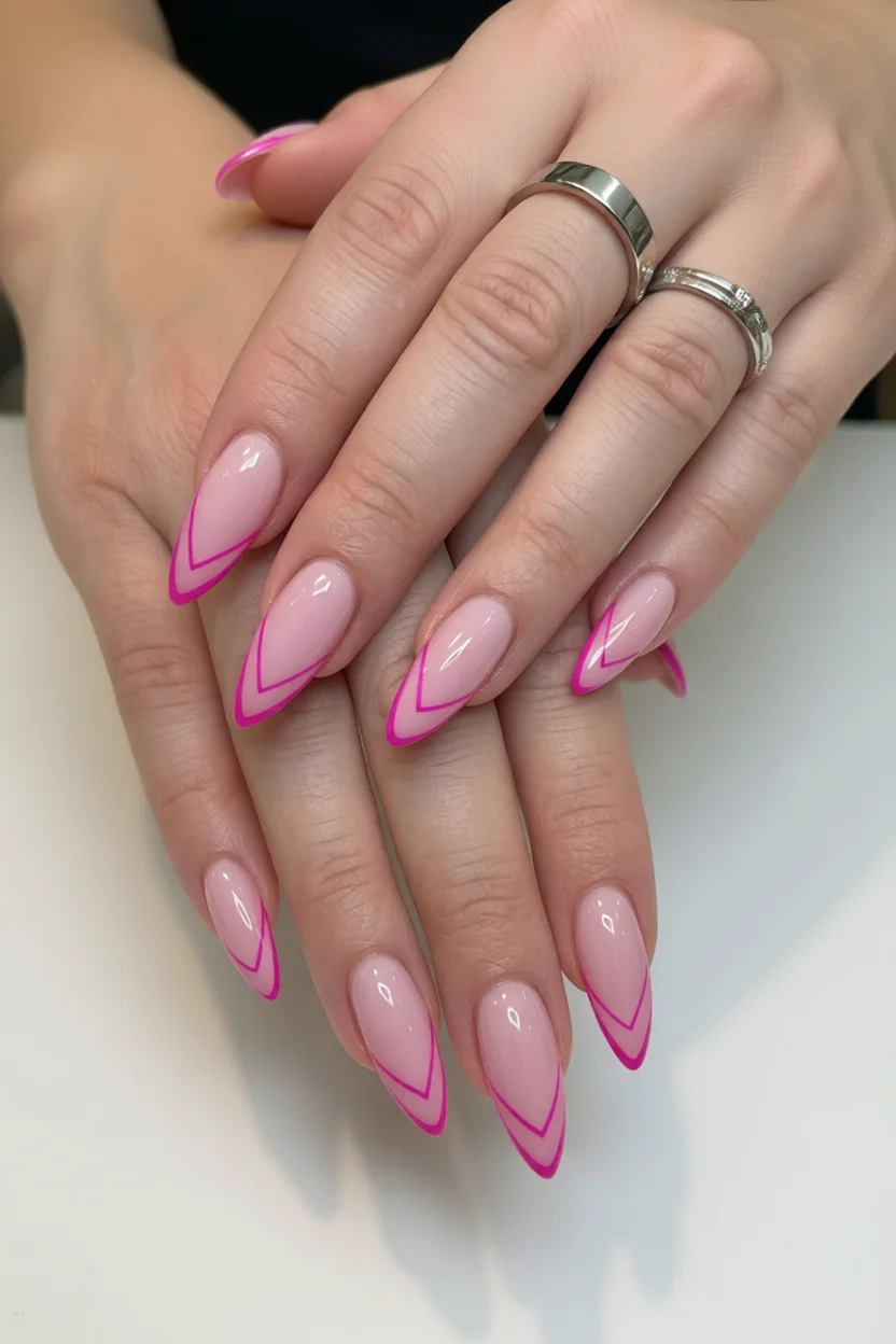 Uñas almendradas largas con base rosa nude y líneas francesas en fucsia vibrante