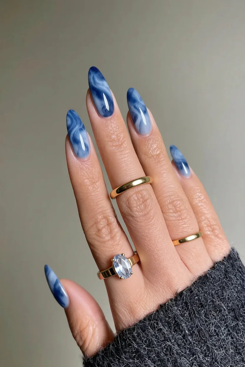 Uñas almendradas con diseño marmoleado en tonos azules bebé e intenso