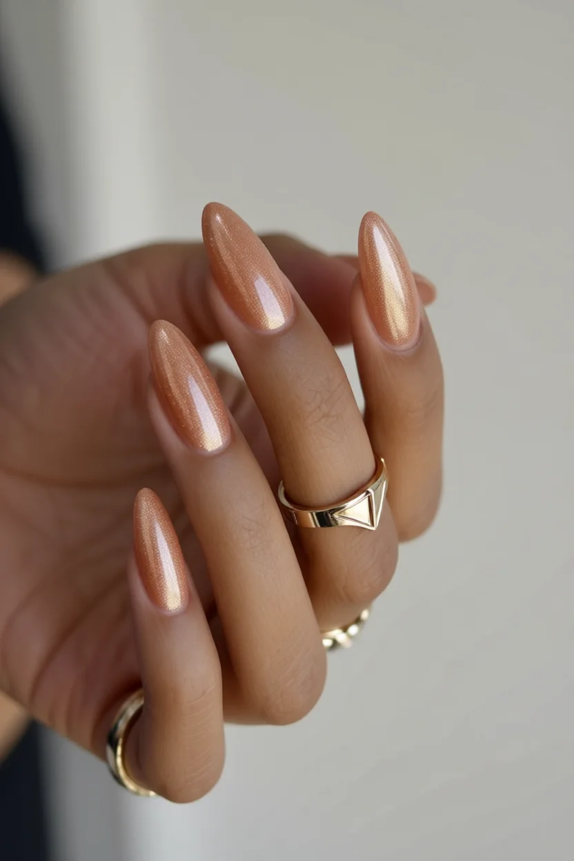 Uñas alargadas almendradas con esmalte durazno metálico brillante
