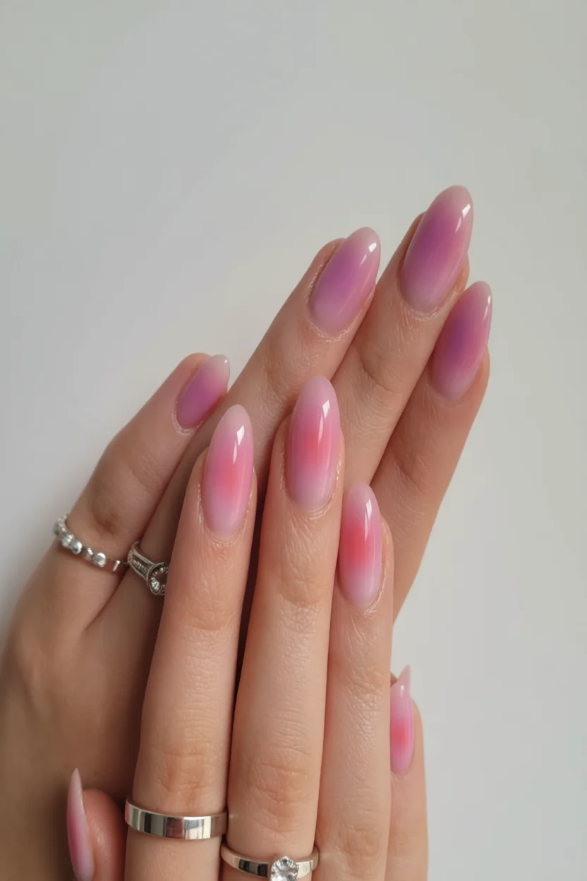 Uñas ovaladas largas con efecto aura en degradado de rosa suave a lila intenso