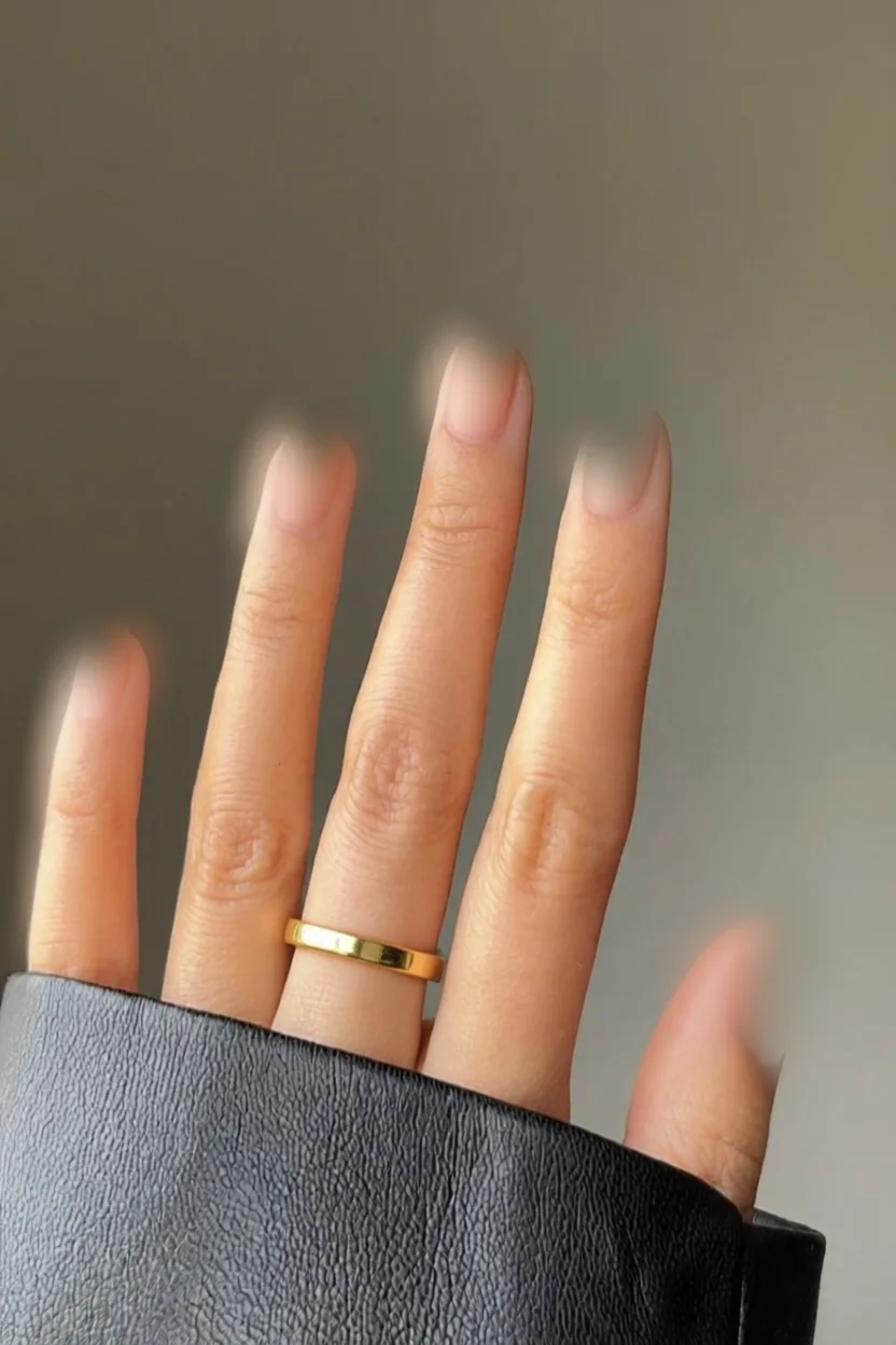 Mano con uñas efecto aura difuminado y anillo dorado