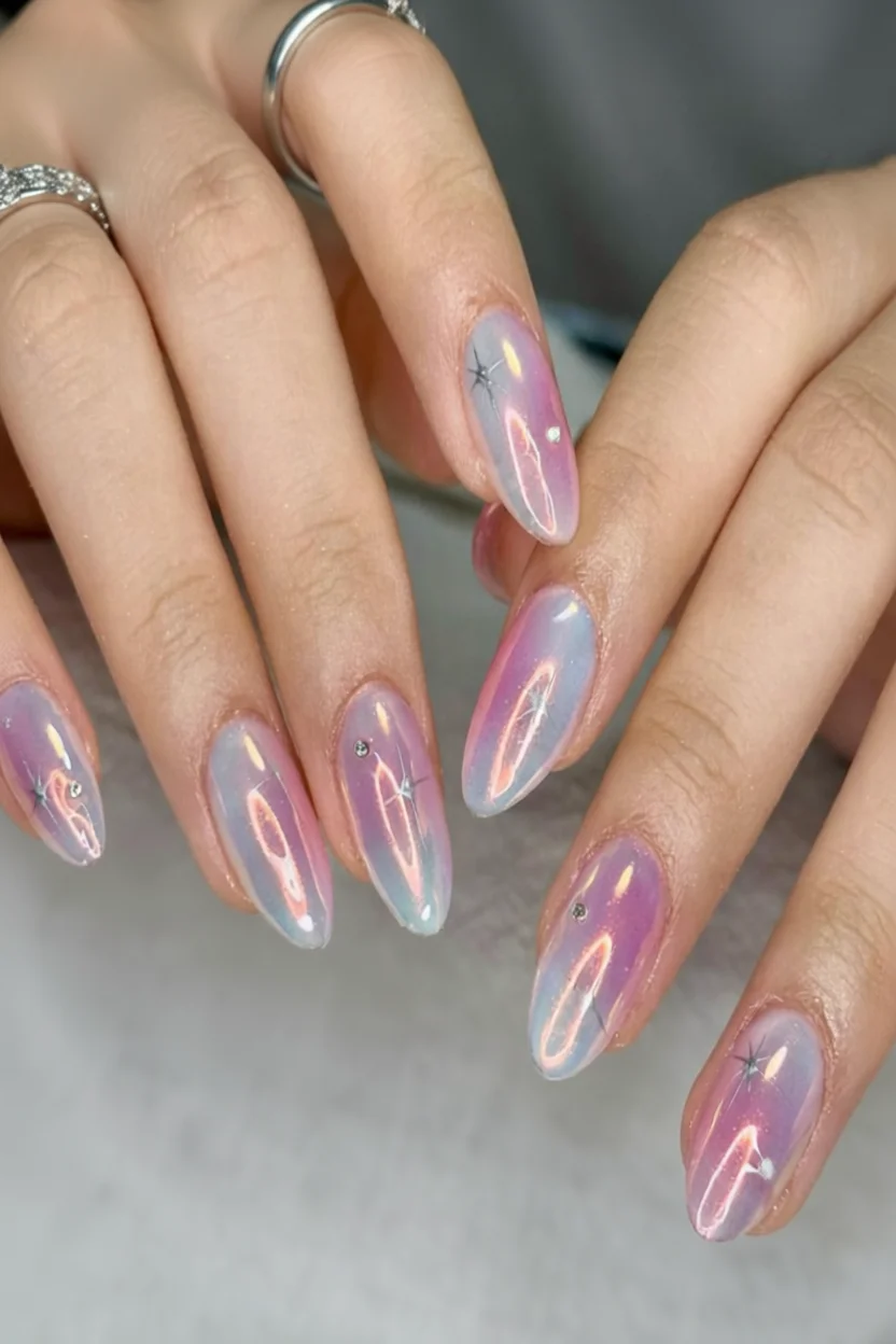 Manicura aura con uñas almendradas en degradado rosado y lavanda con cristales decorativos