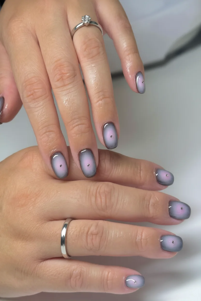 Uñas cortas con efecto aura degradado gris-lila y brillo central