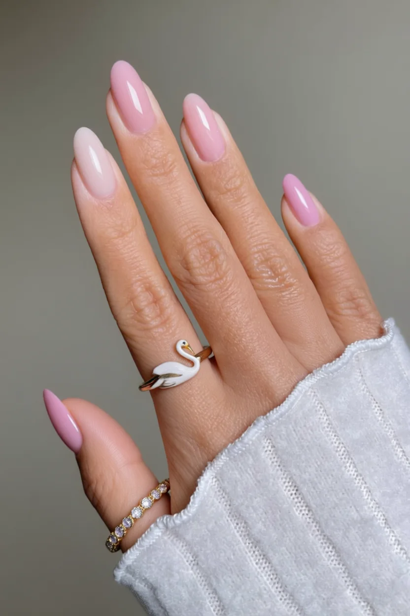 Mano con uñas ovaladas en degradado rosa y efecto gelatina brillante