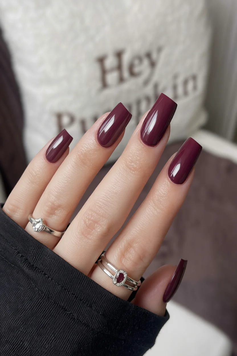 Mano con uñas coffin barnizadas de vino tinto brillante