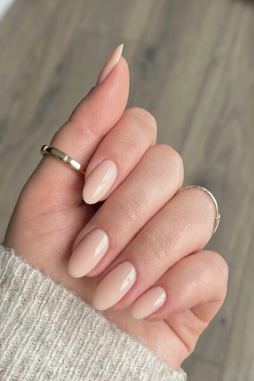 Mano con uñas ovaladas en tono nude con efecto degradado brillante y acabado glossy