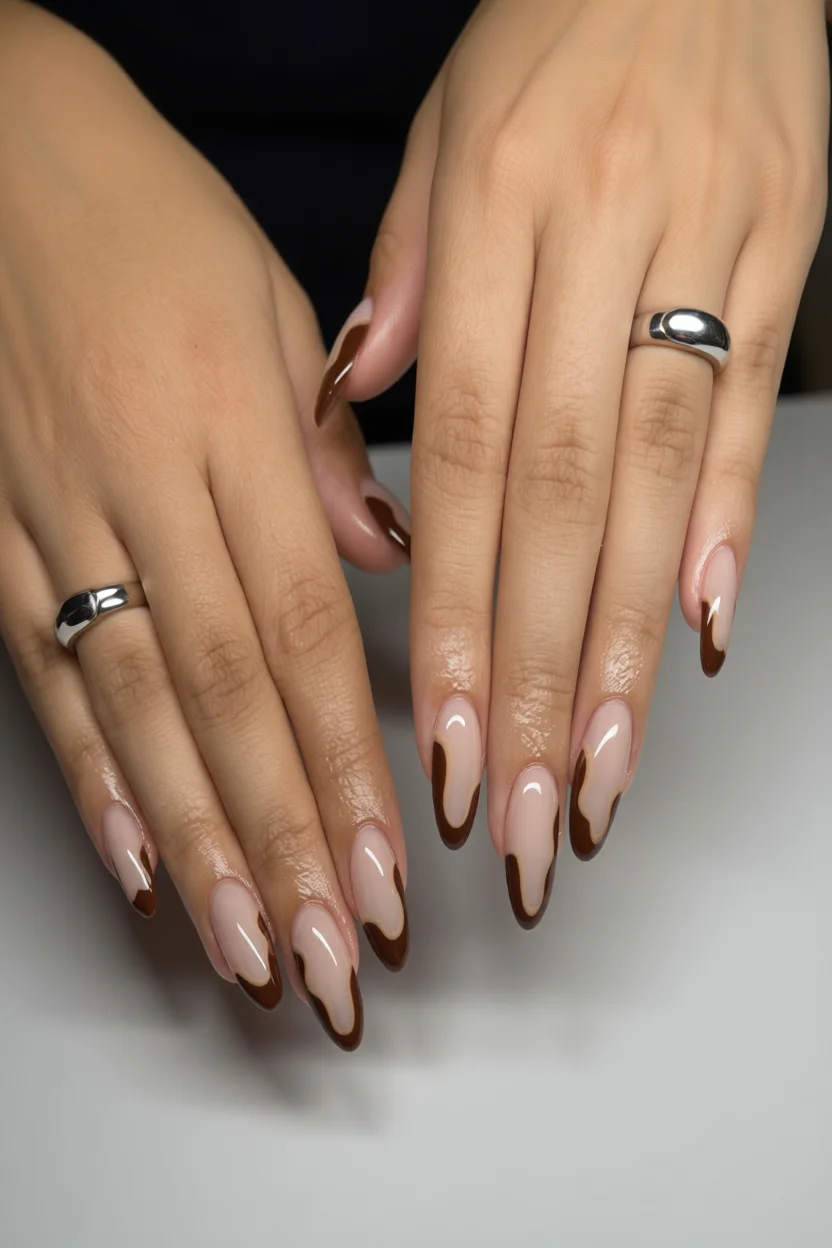 Uñas almendradas con french marrón irregular y base nude