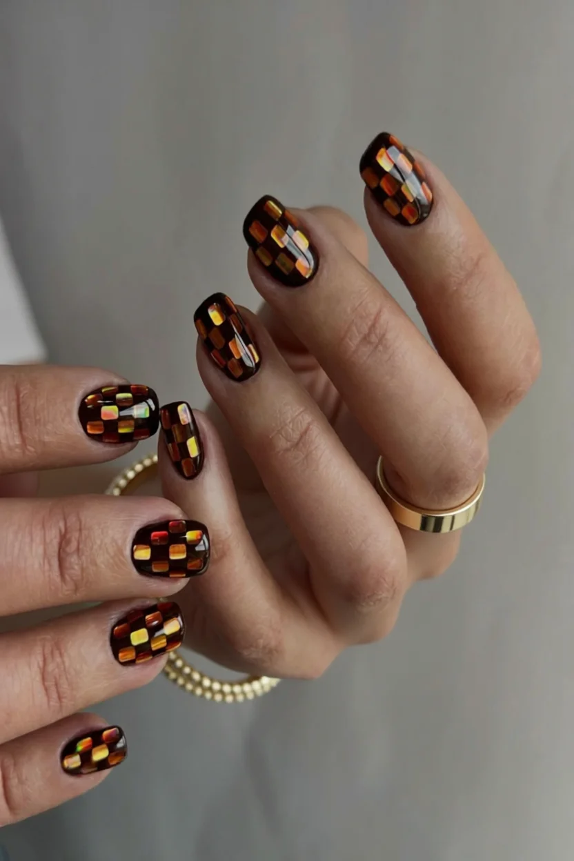 Uñas cortas cuadradas con diseño ajedrezado en tonos ámbar, marrón y mostaza