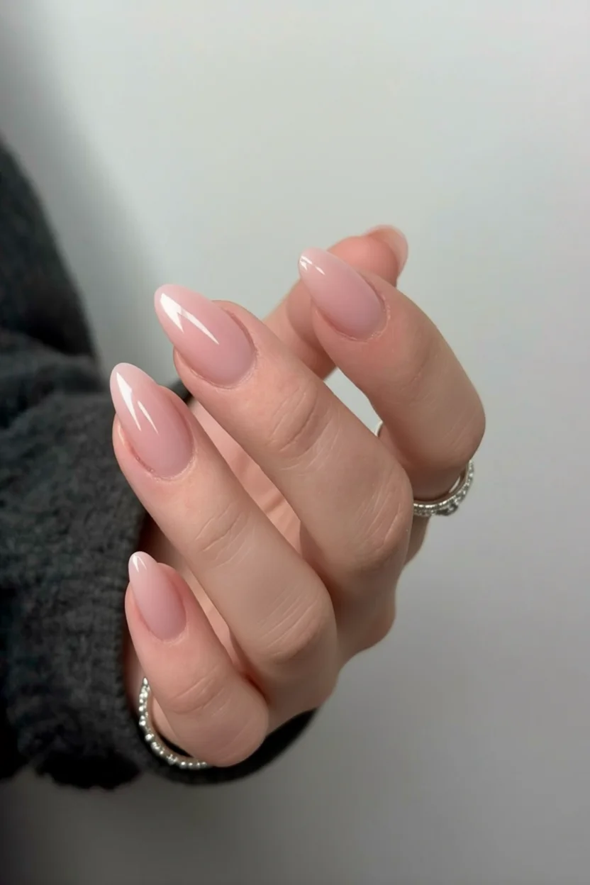 Uñas largas en forma de almendra con esmaltado rosa nude brillante