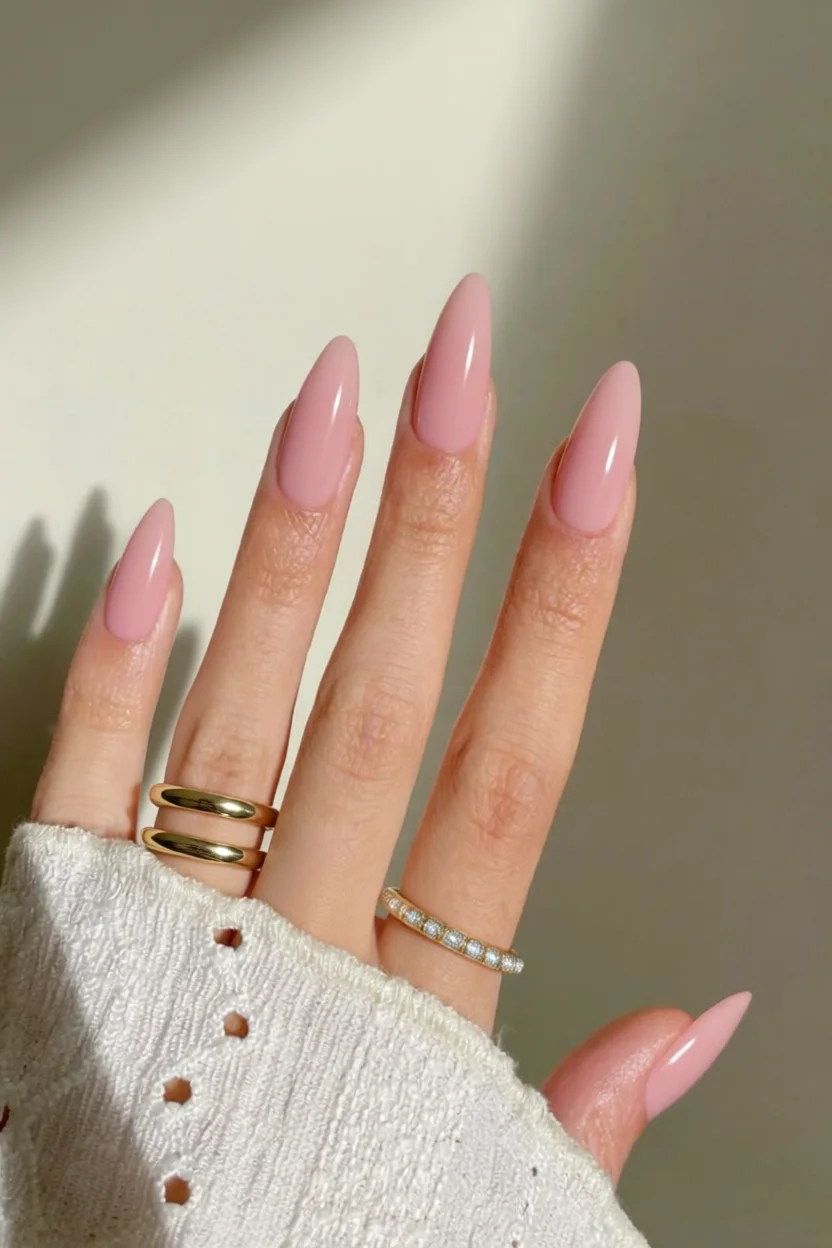 Mano con uñas almohadilla largas esmaltadas en rosa pastel sólido