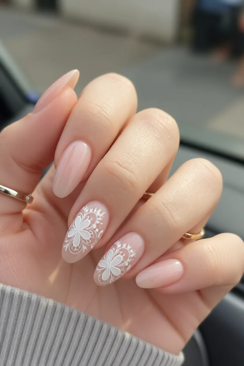 Manicura ovalada con flores blancas estilo encaje sobre base rosa nude