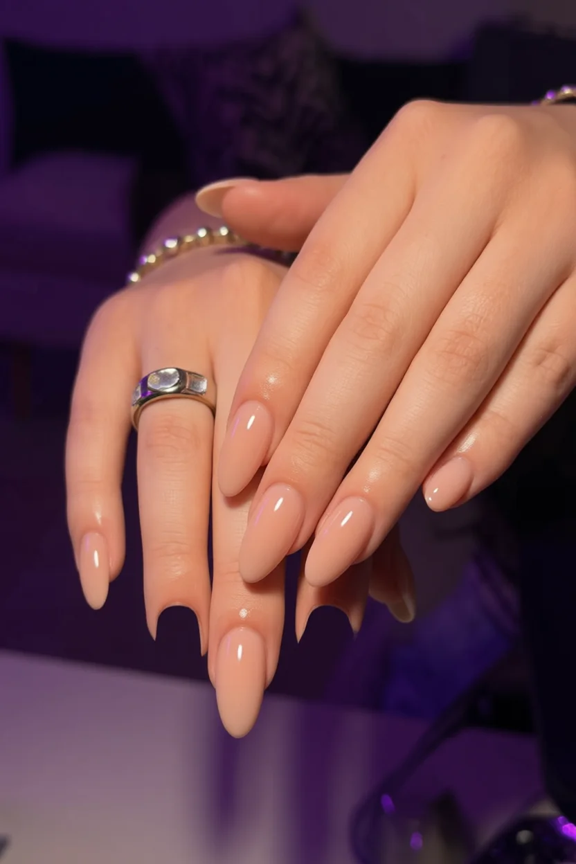 Mano con uñas largas forma almendra y esmalte nude brillo intenso