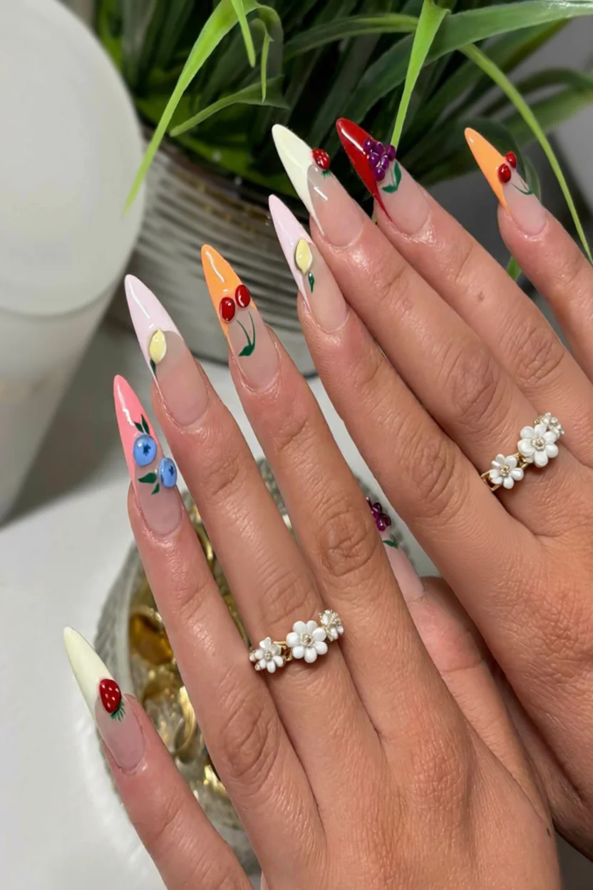 Uñas estilo stiletto con diseños de frutas como fresas, cerezas, arándanos y uvas