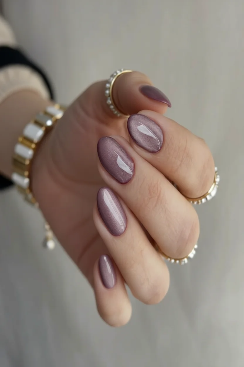 Mano con manicura cromada en tono uva metálico