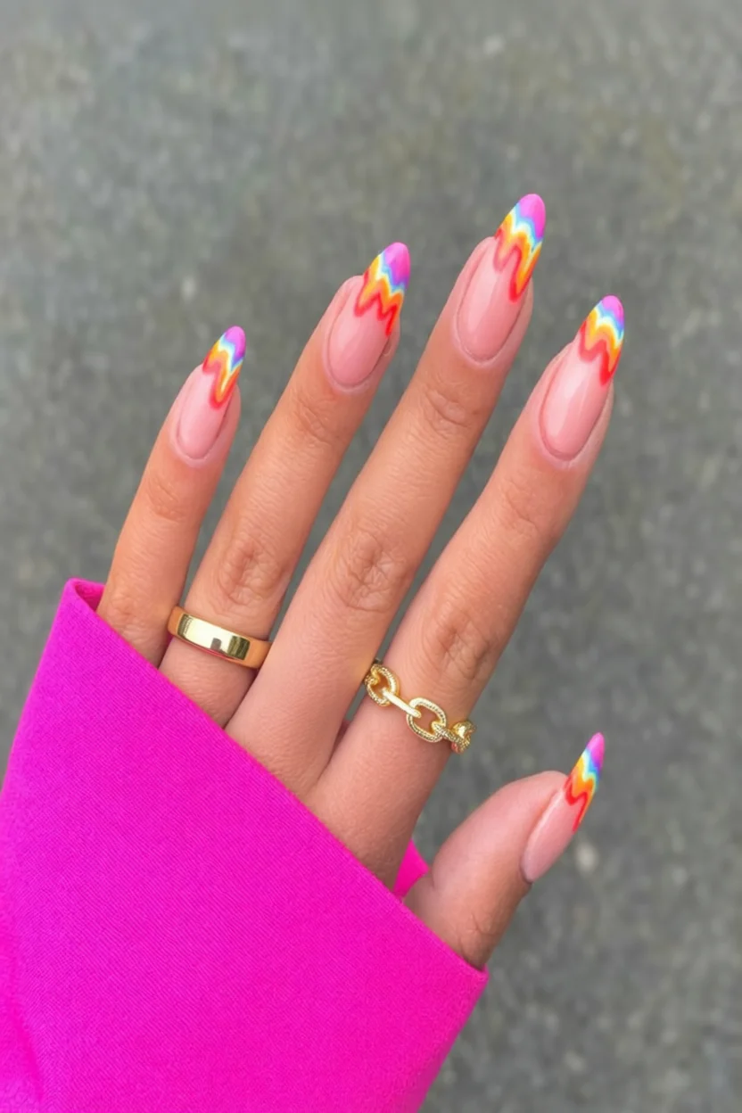 Uñas largas en forma almendra con base rosa y diseño de llama arcoíris en las puntas