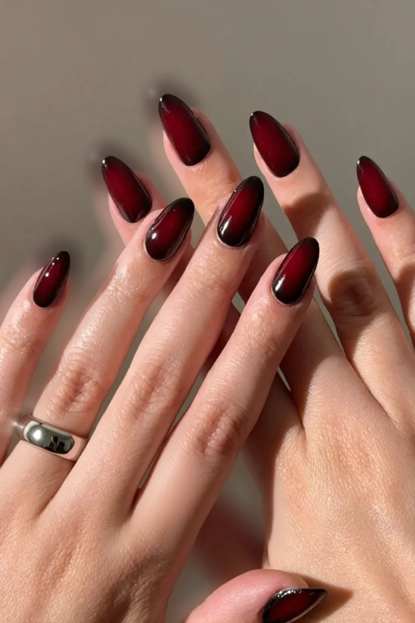 Uñas largas almendradas con degradado rojo vino y efecto brillante