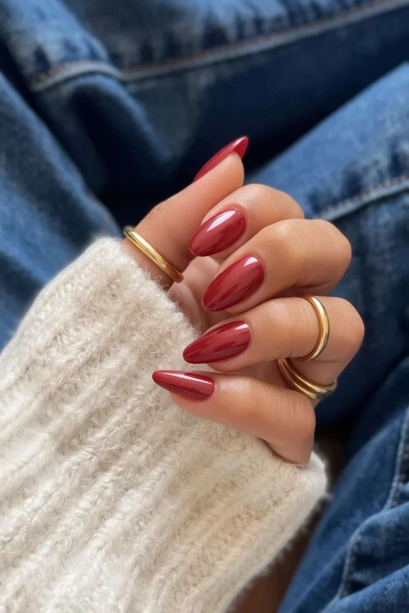 Mano con uñas largas en forma de almendra pintadas de rojo brillante
