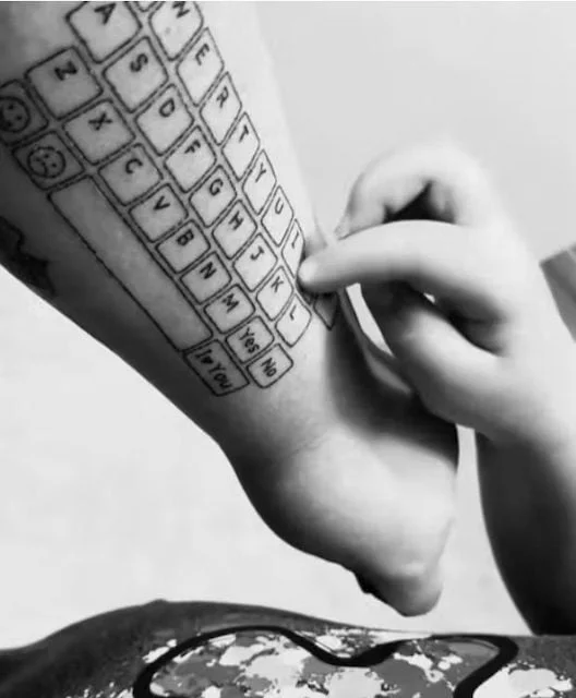 Hunter tecleando en el tatuaje del brazo de su madre
