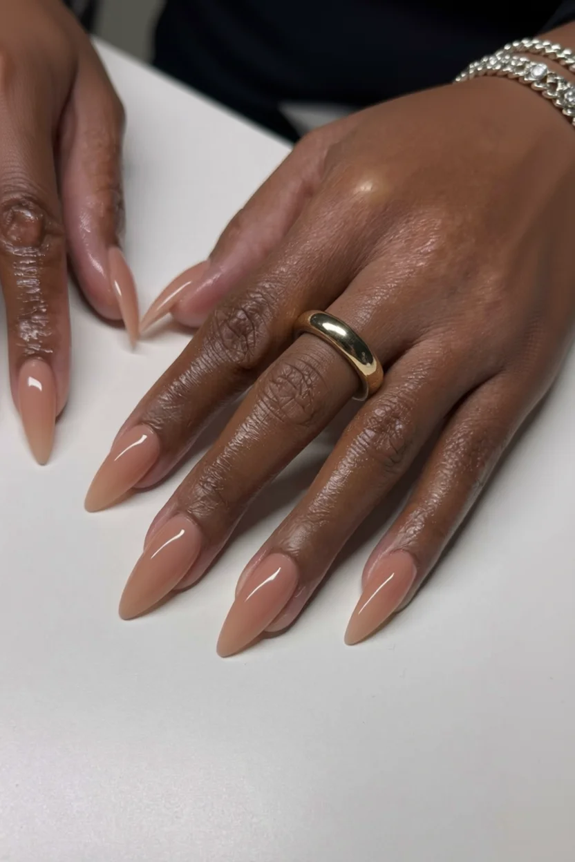 Uñas puntiagudas estilo stiletto en tono nude con brillo intenso