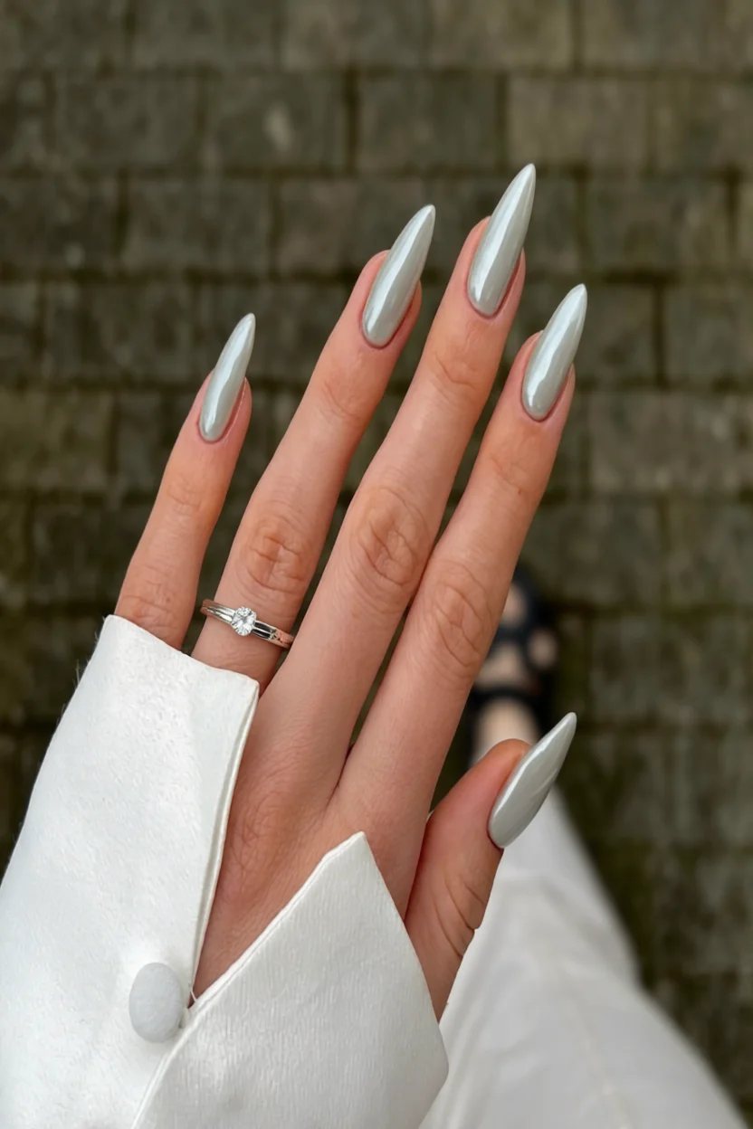 Uñas largas stiletto con acabado metálico plateado brillante