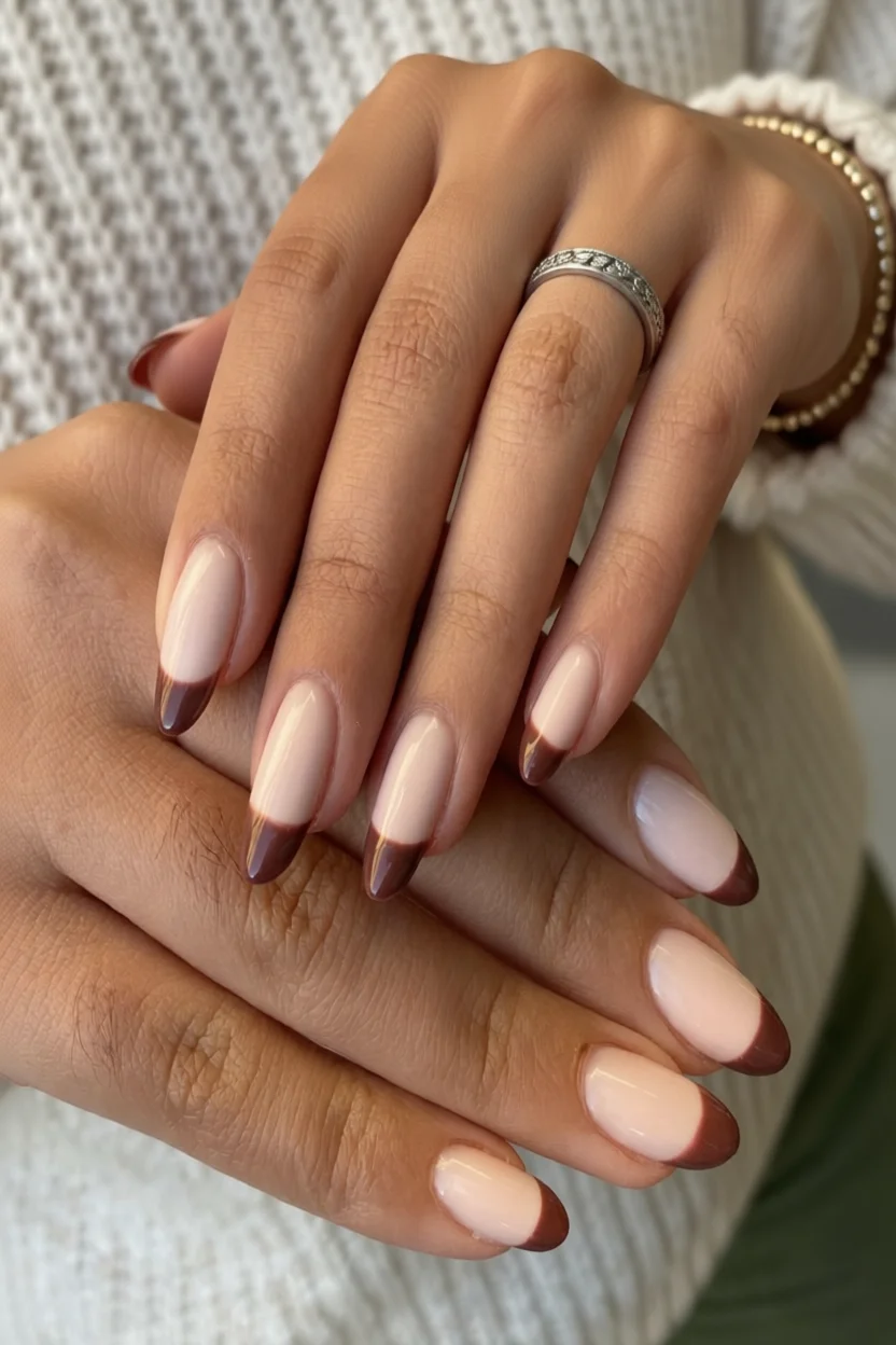 Manos con uñas ovaladas en diseño French con puntas marrones oscuras