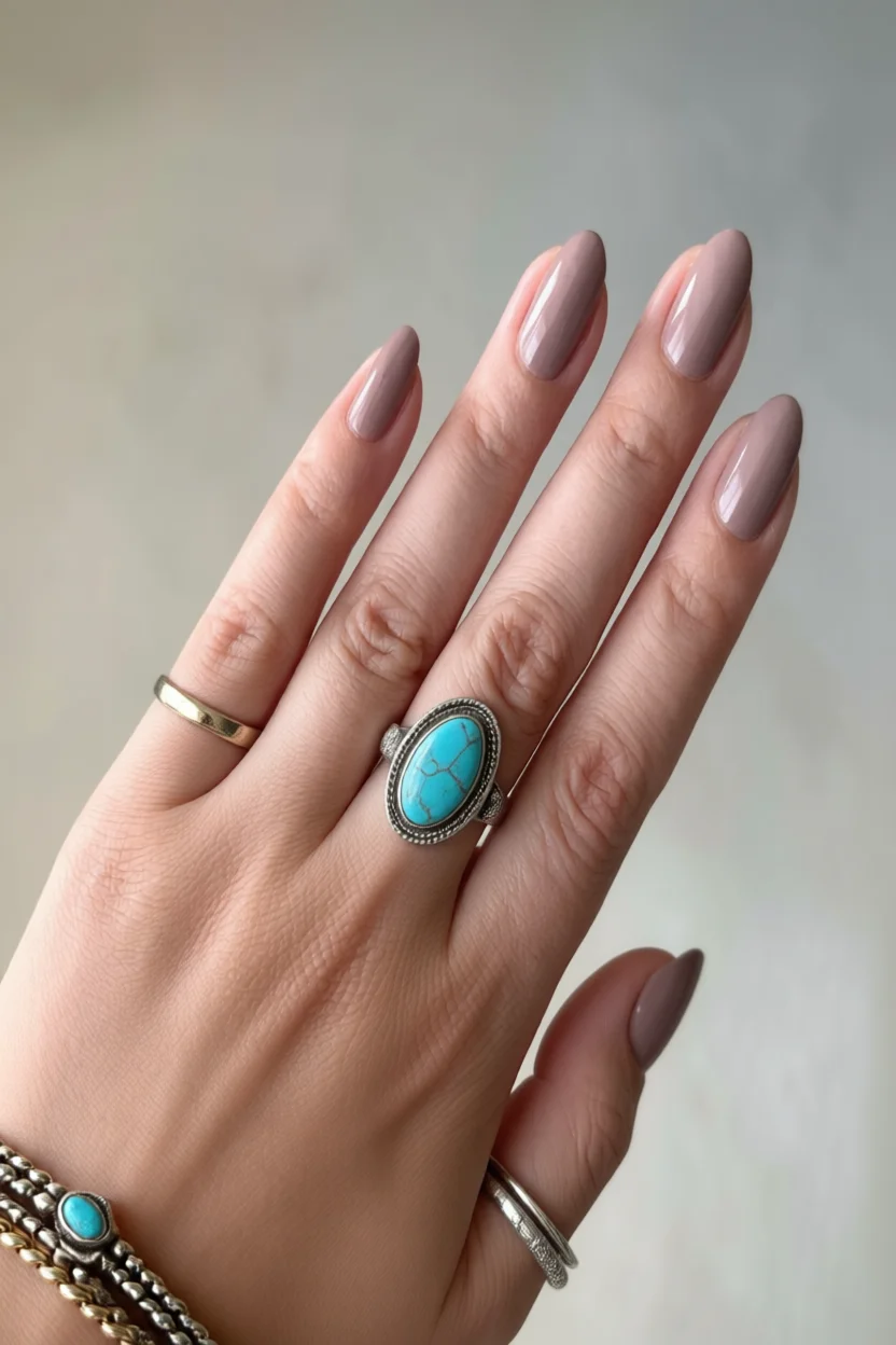Mano con uñas almendradas pintadas de color rosa empolvado mate