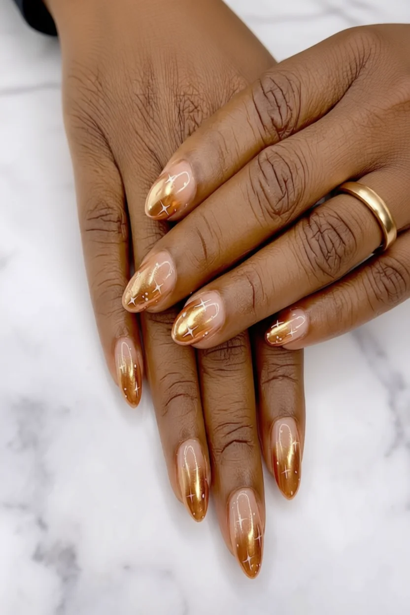 Uñas almendradas degradado dorado con brillos estelares